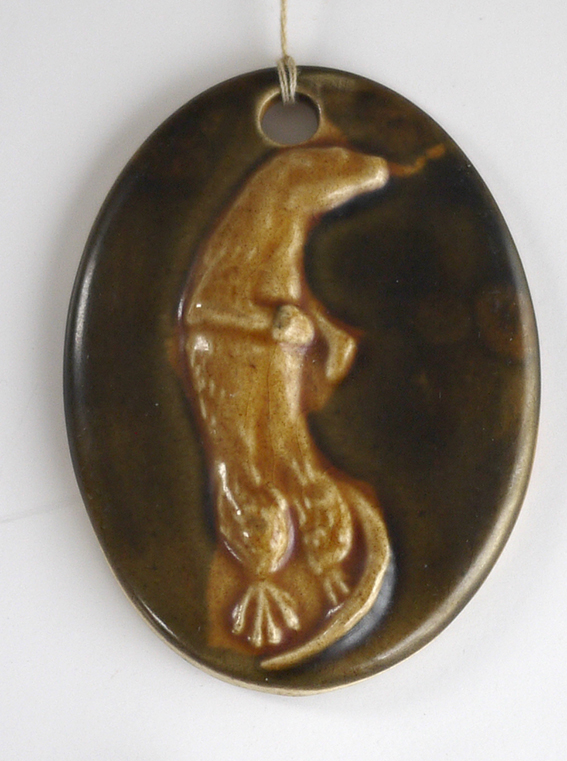 unusual glazed pottery pendant with otter relief